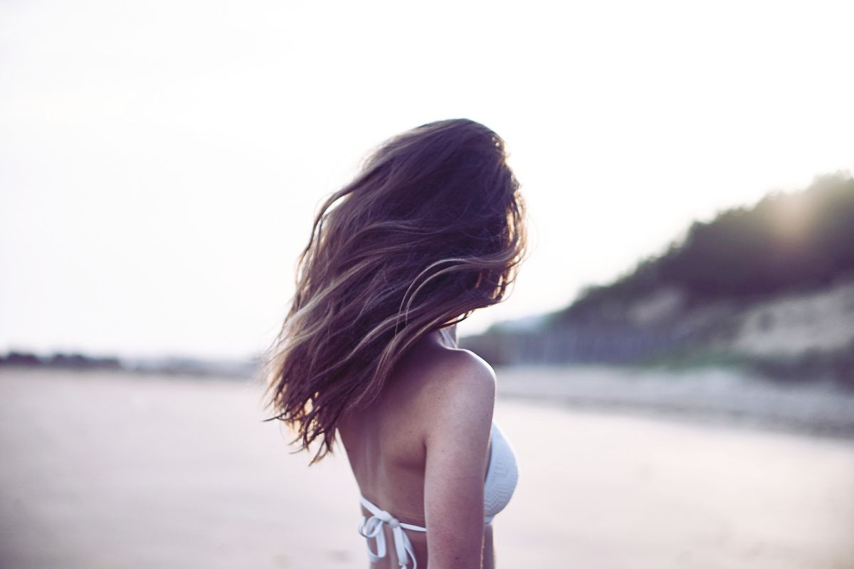 Femme de dos, en maillot de bain sur la plage