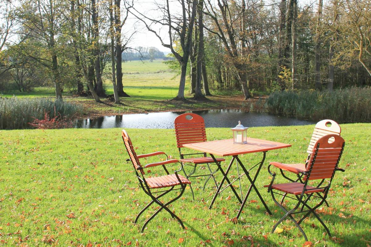 Mobilier de jardin en bois et en métal, dans un beau jardin devant une rivière