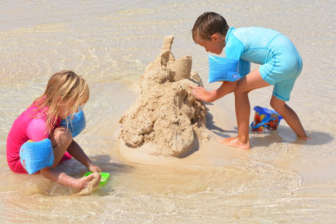 Deux enfants qui font un château de sable sur la plage