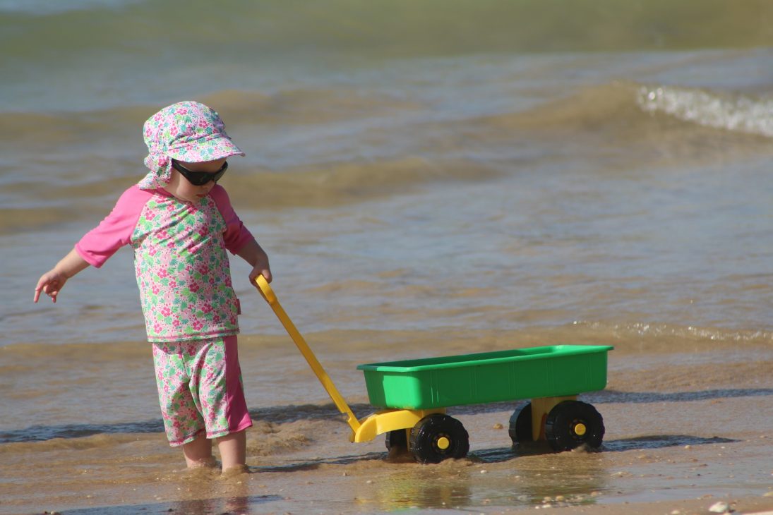 Enfant qui traine un chariot à la plage