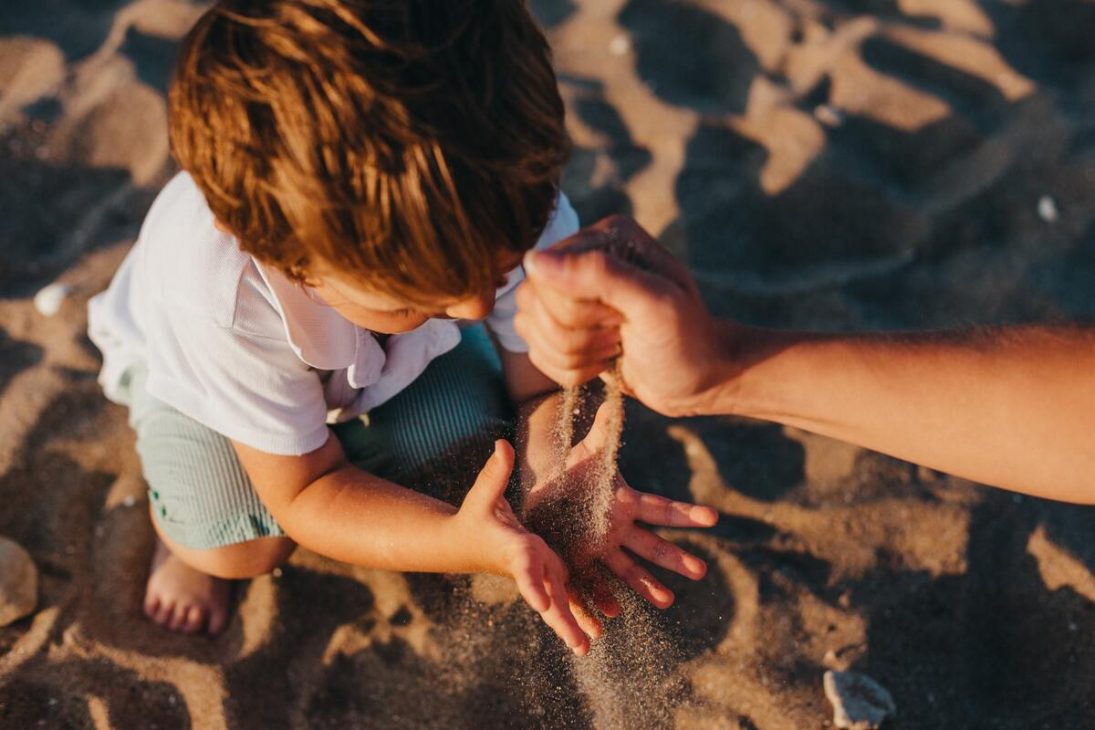 Petit garçon qui joue avec du sable sur la plage