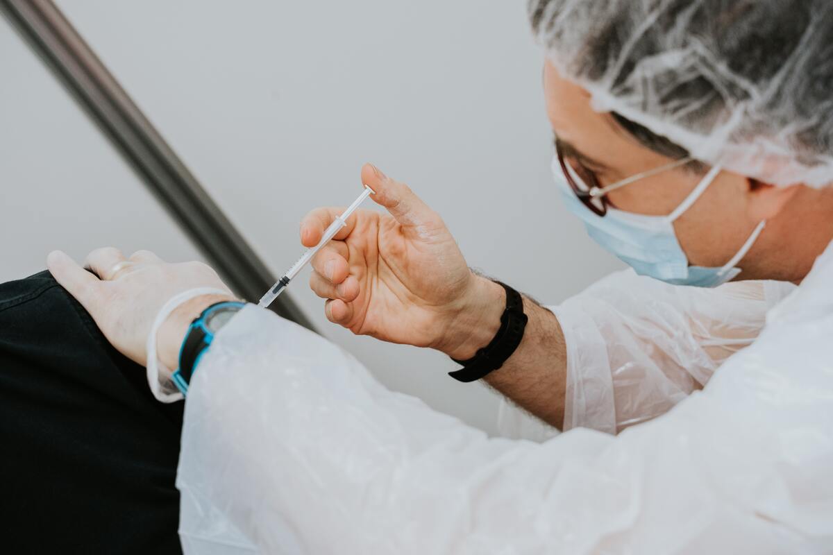 Homme en train de vacciner un patient contre la covid-19