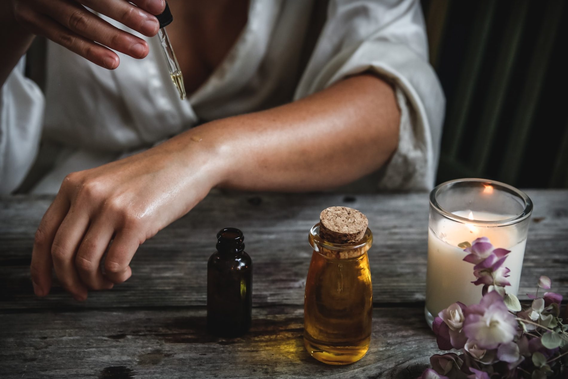 Femme qui s'applique des huiles essentielles sur l'avant bras dans le cadre de l'aromathérapie