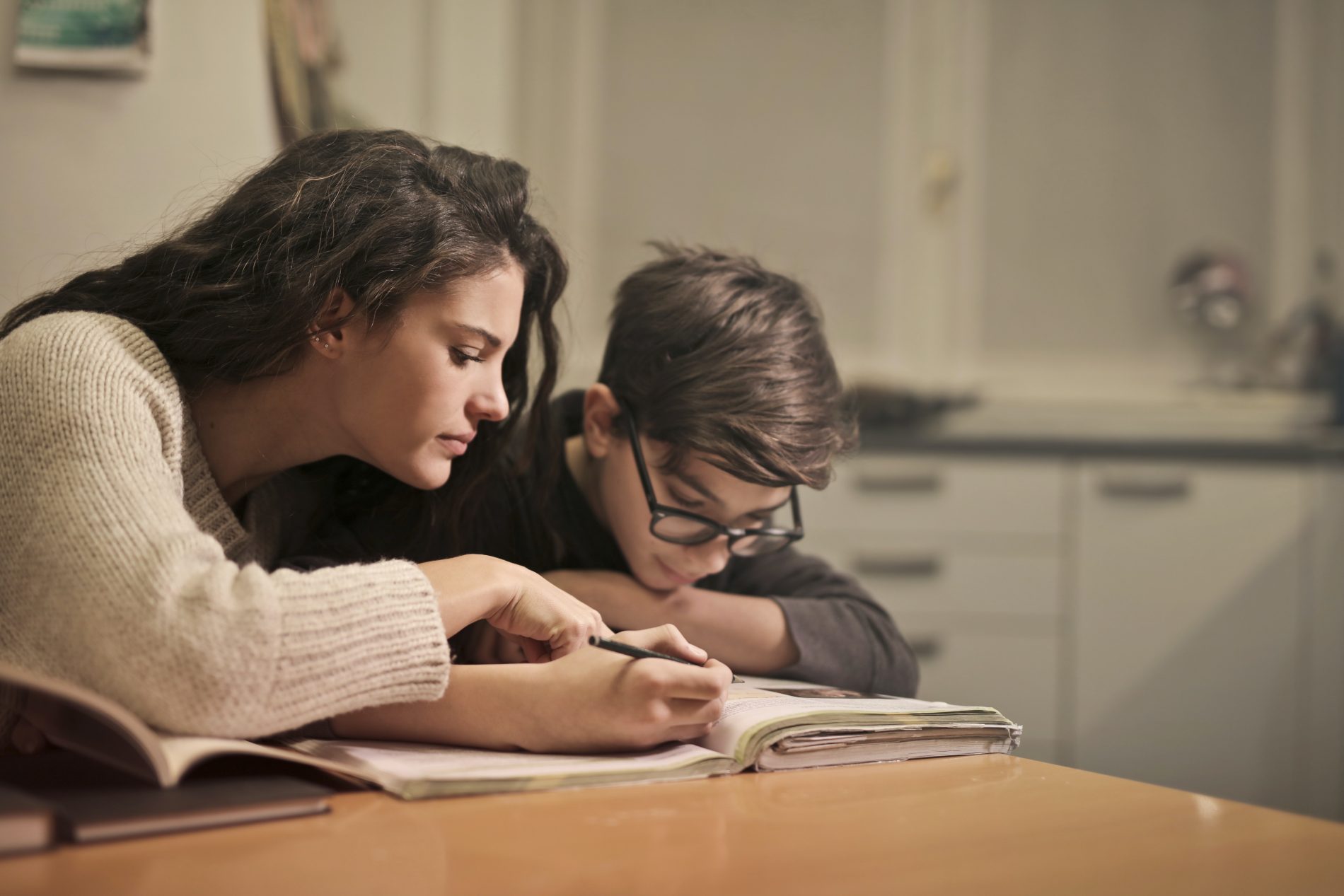 Femme qui aide un enfant à faire ses devoirs