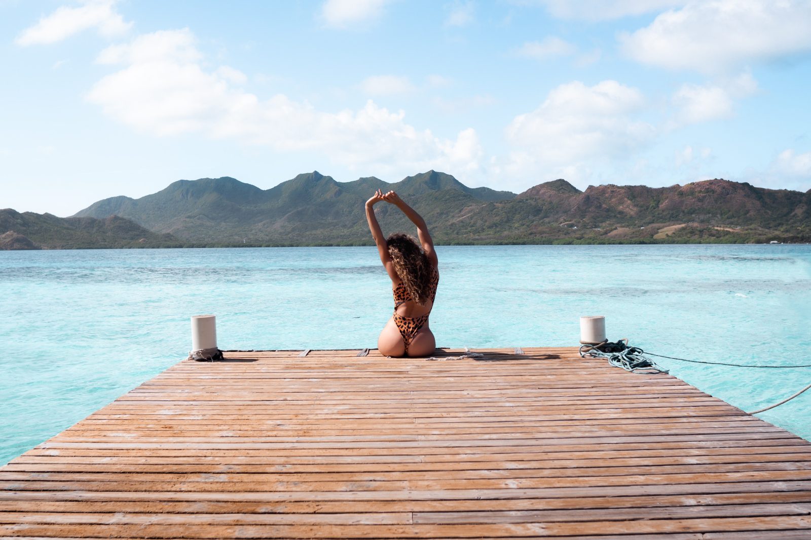 Femme en maillot de bain qui s'étire sur un ponton