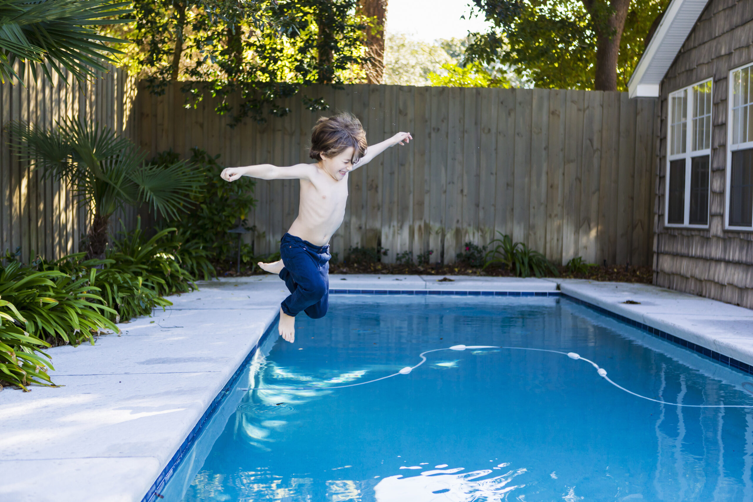 Jeune garçon qui saute dans une piscine sans sécurité