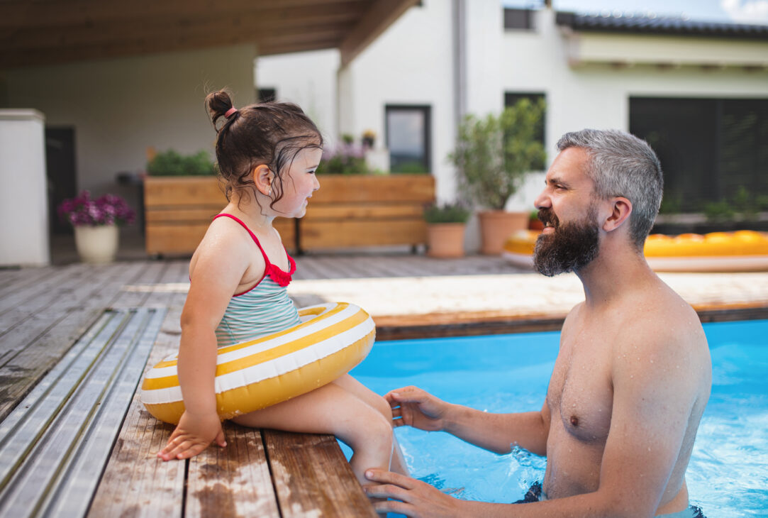 Un père et sa fille au bord d'une piscine pour prévenir des accidents domestiques