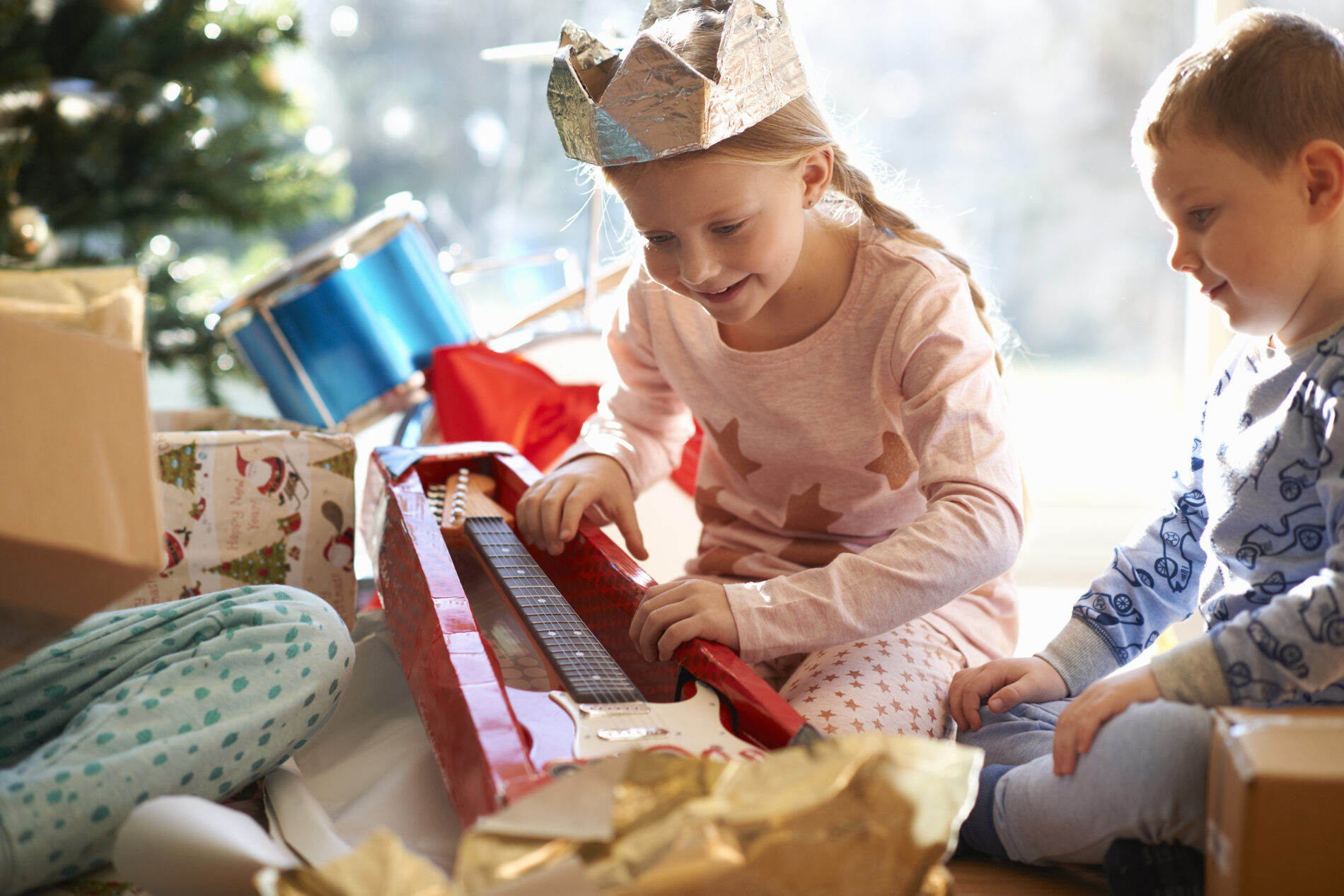 Fille et garçon qui ouvrent leurs cadeaux de Noël 2023