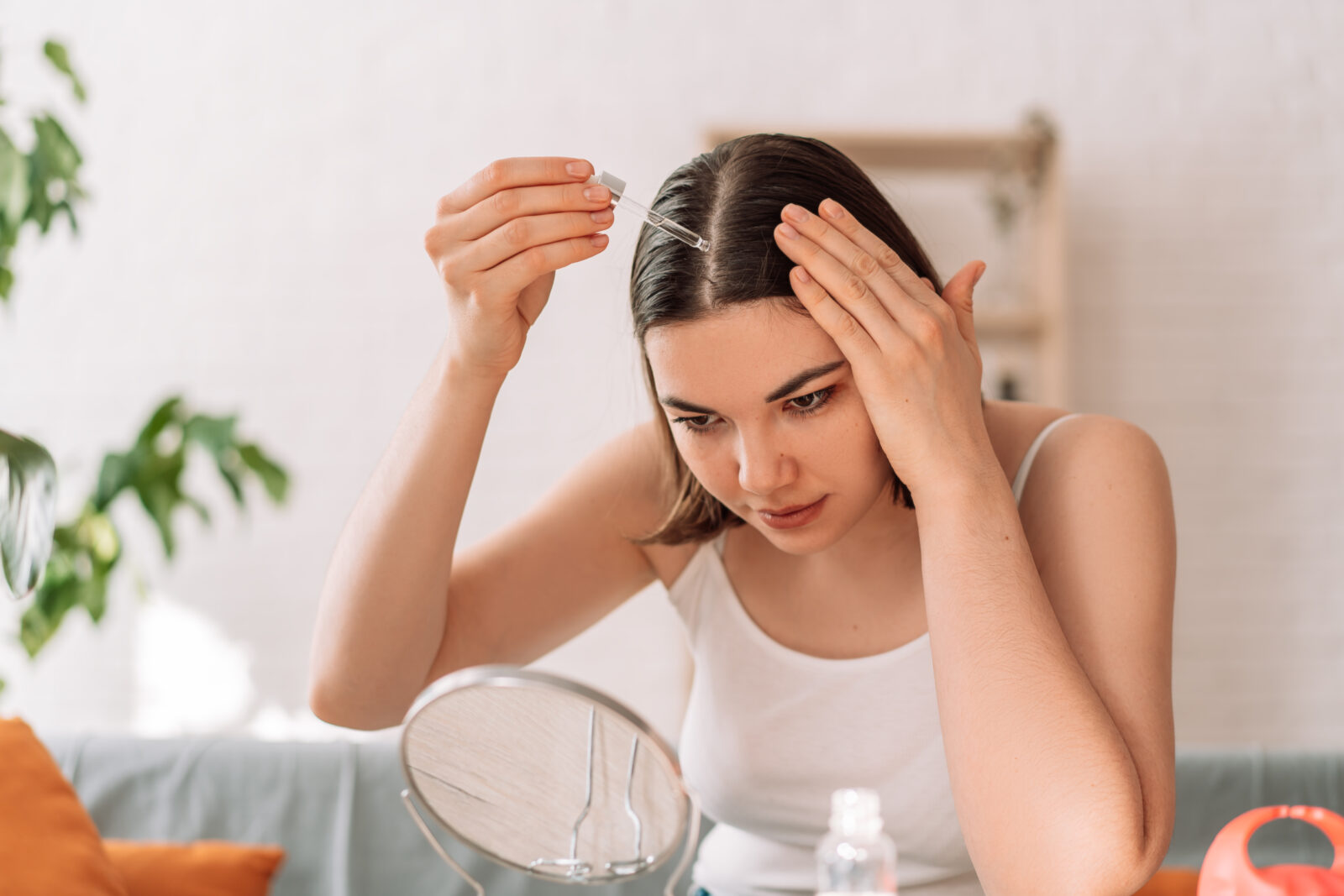 Femme qui met de l'huile de ricin dans ses cheveux